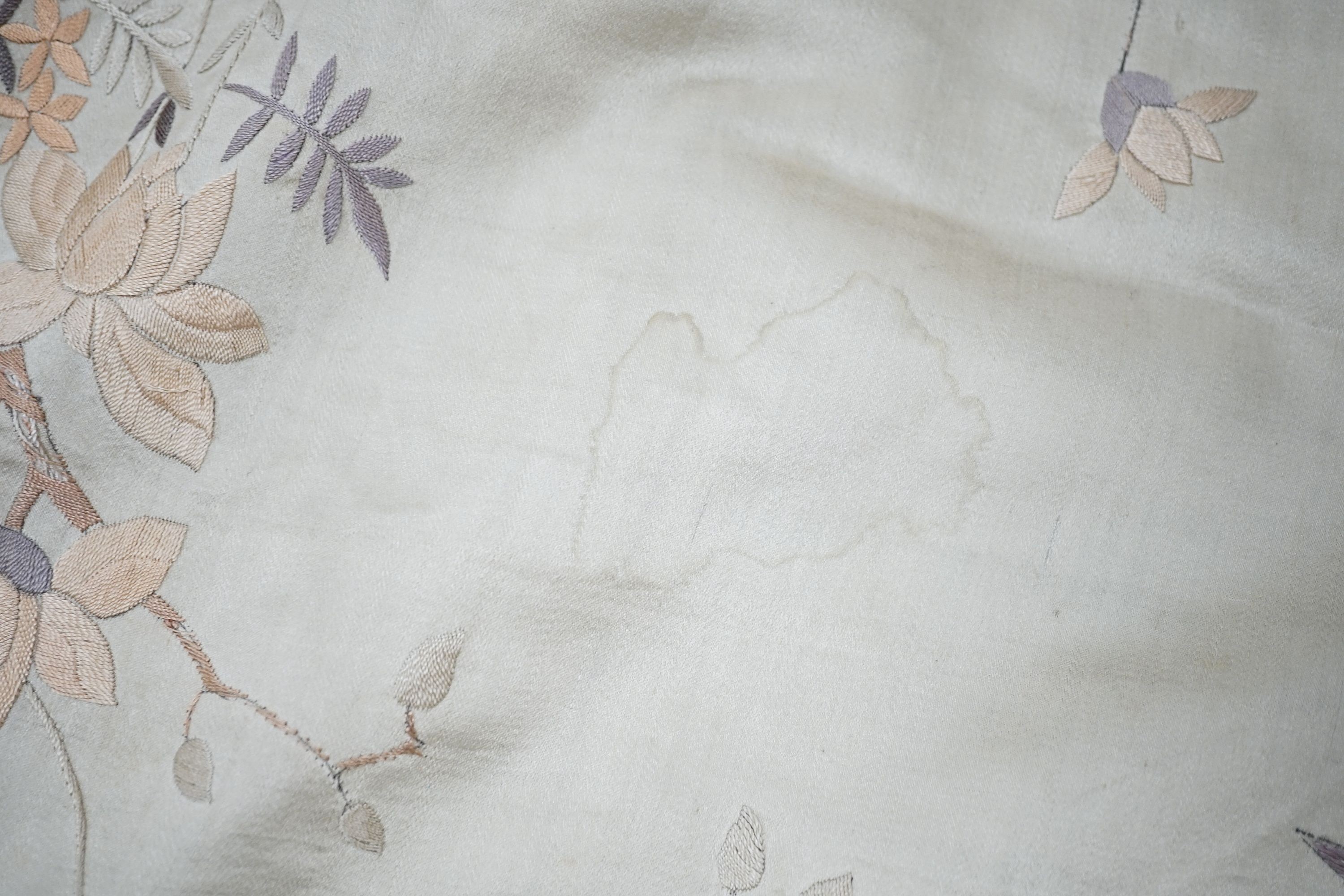 A grey silk satin Chinese embroidered panel edged with deep fringing covered with pale grey pink and beige embroidery and birds and flowers, 78 x 96cm excluding fringing